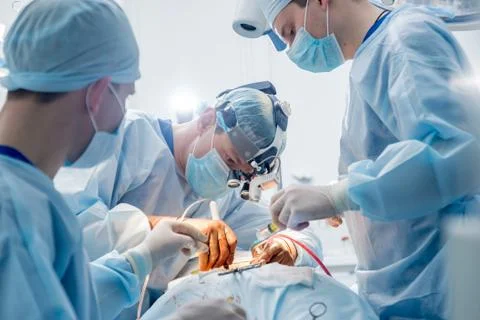 Spinal surgery. Group of surgeons in operating room with surgery equipment. Stock Photos