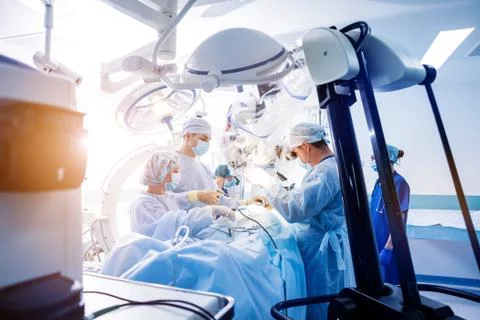 Spinal surgery. Group of surgeons in operating room with surgery equipment. Stock Photos