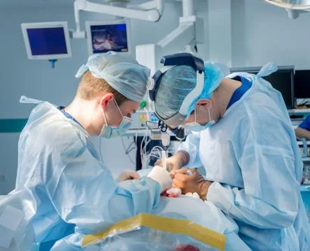 Spinal surgery. Group of surgeons in operating room with surgery equipment. Stock Photos