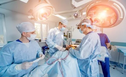 Spinal surgery. Group of surgeons in operating room with surgery equipment. Stock Photos