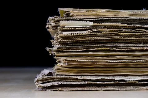 The spines of old books lying on the stack. Books stacked on an old table. Stock Photos