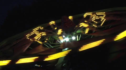 Spining fair ground ride, push in to MCU, nightime.  Real time. Stock Footage 27555038