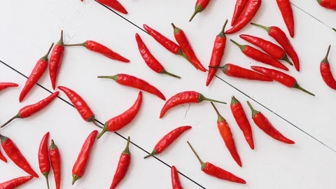 Spining in Slow Motion Red hot little chili peppers pattern isolated on white Video stock 129674378