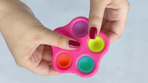 A spinner toy, drinking in a womans hand on a white background. The spinner Video stock 318133907