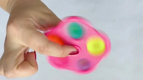 A spinner toy, drinking in a womans hand on a white background. The spinner Stock Footage 318134294