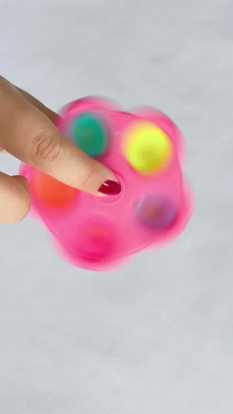 A spinner toy, drinking in a womans hand on a white background. The spinner Stock Footage 318134465