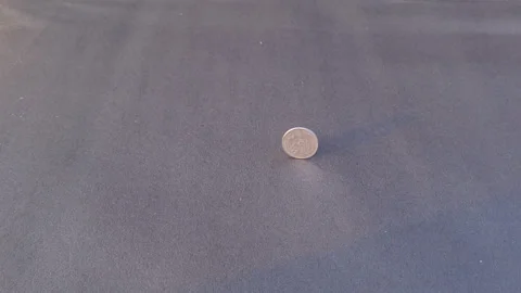 Spinning And Tipping Over A Two Rupees Indian Coin On Dark Floor in Slow Motion Stock Footage 266664229