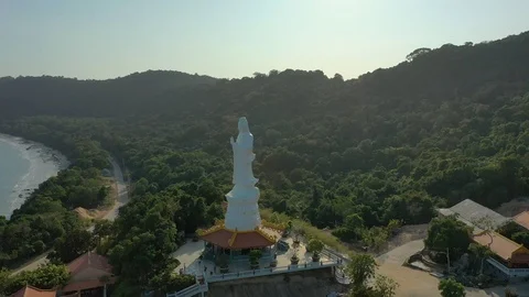 Spinning around monument at the temple below mountains in sunset in Phu Quoc isl Stock Footage 124326526