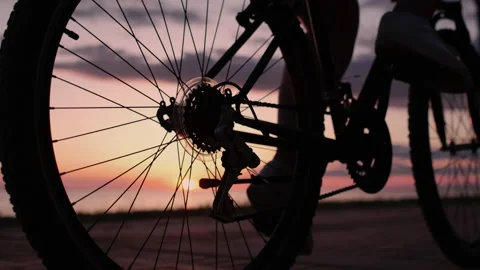 Spinning a Bicycle Wheel on Sunset Background at Summer. Silhouette of Cyclist Stock Footage 196088124