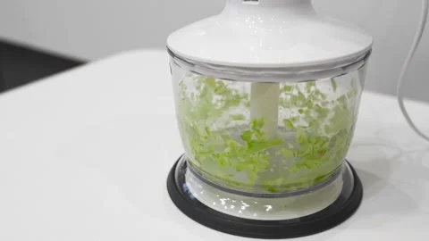 The spinning blade of the blender grinds the celery Stock Footage 321418527