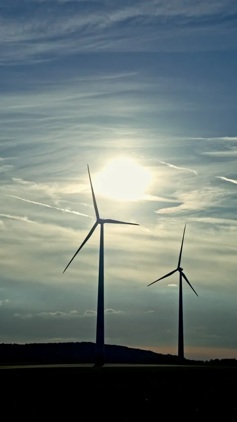 Spinning blades dance against a sunset sky in a peaceful landscape of wind Video stock 320100638
