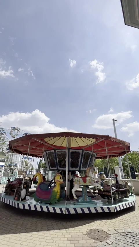 Spinning carousel in a green park agains... | Stock Video | Pond5