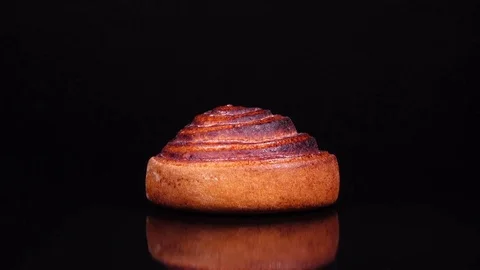 Spinning cinnamon roll isolated on black background. 4k Vídeo Stock 73085886