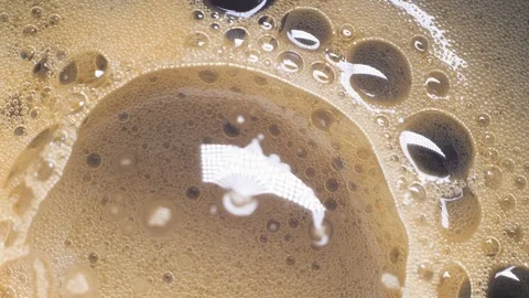 Spinning coffee bubbles in a cup. Abstract background. Macro top view Stock Footage 73701728