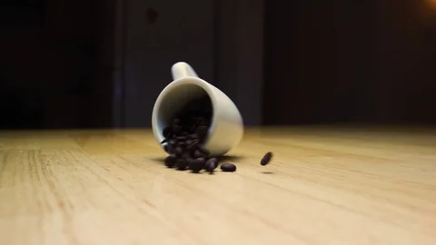 Spinning coffee cup throwing coffee beans in slow motion Stock Footage