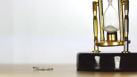 Spinning coin and sand clock Stock Footage 82637005
