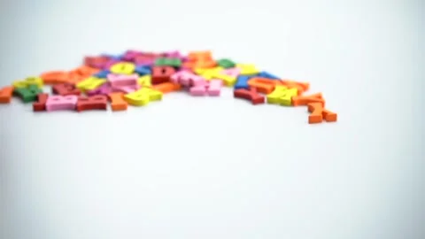 Spinning colored letters on a white table. Stock Footage 160913584