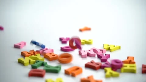 Spinning colored letters on a white table. Stock Footage 160913602
