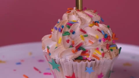 Spinning cupcake or cake with a candle on a pink background Stock Footage 166553264