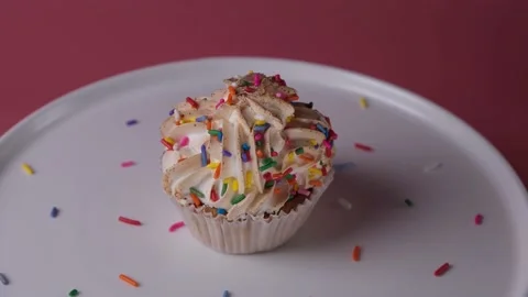 Spinning cupcake or cake with a candle on a pink background, Stock Footage 166683077