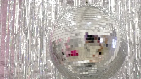 Spinning disco ball on the background of a wall decorated with silver sequins Stock Footage 165583604