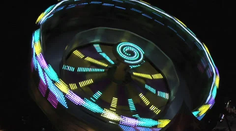 Spinning fair ground ride, static at night Medium Shot.  short pull out. Stock Footage 27636151