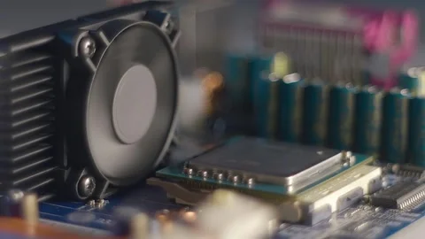 Spinning fan on radiator and processor nearby on computer motherboard Stock Footage 313179956