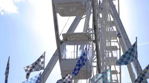 Spinning Ferris wheel, flags blow in the wind Video stock 74853162