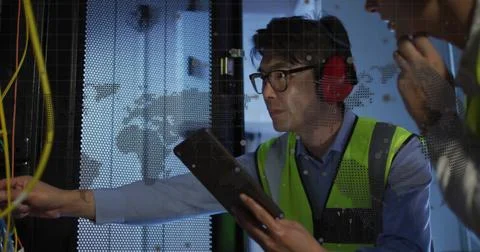 Spinning globe and world map against diverse male and female engineers working Stock Photos