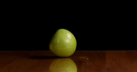 Spinning a green apple on table isolated Video stock 126258615