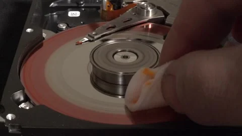 Spinning hard disk, colored red, with flashes of light and surface cleaning Stock Footage 320835670