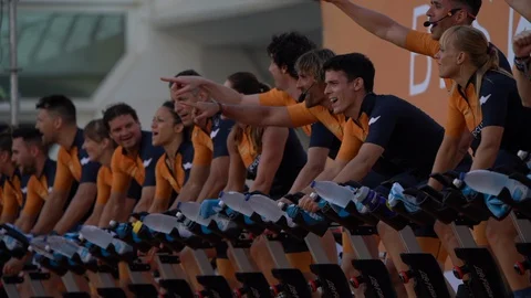Spinning instructors lead hundreds of people on fixed spin bikes as they attempt Stock Footage 127895637