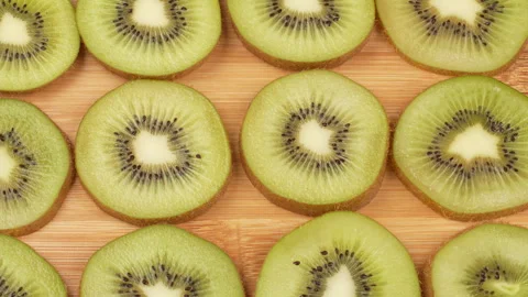 Spinning Kiwi Slices Pattern Top Down Loop on Wooden Board Stock Footage 319915164