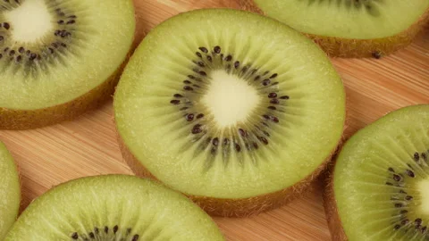 Spinning Kiwi Slices Pattern Top Down Loop on Wooden Board Stock Footage 319915365