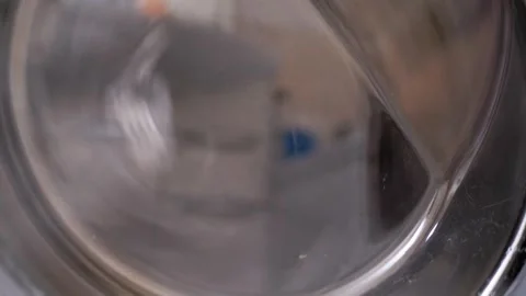 Spinning Laundry Inside a Washing Machine Drum Coming to a Complete Stop Stock Footage 338997080