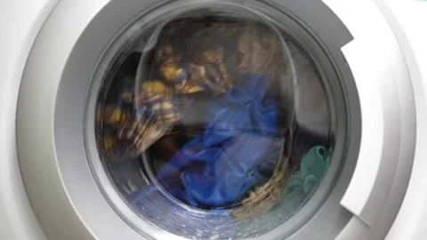 Spinning laundry machine with dirty cloth textile soap water household washing Stock Footage 336563870