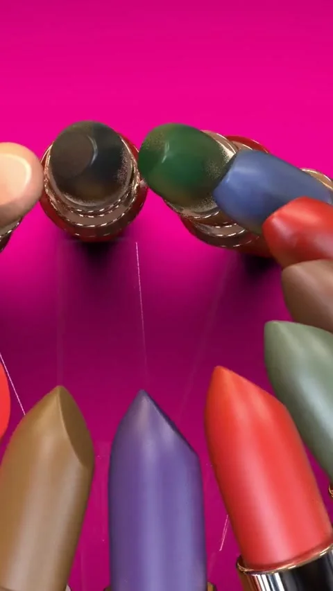 Spinning lipstick tubes on a pink surface. Vídeos de archivo 335708177