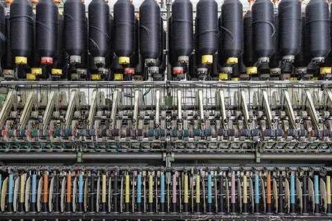 Spinning machine with rows of yarn cones and spindles in a textile factory Stock Photos