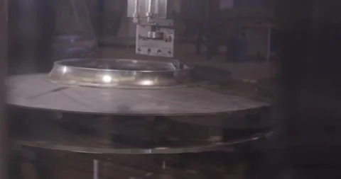 Spinning Metal Disc in a Hazy Workshop Hall, Rotating Machine, Wide Shot Stock Footage 340357037