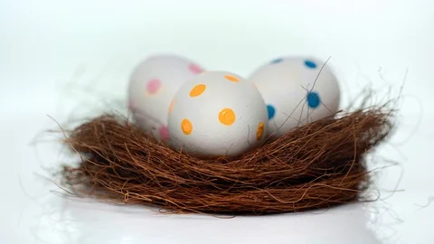 Spinning nest with dotted easter eggs on white Stock Footage 124537083