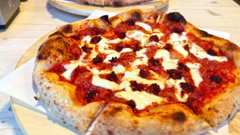 Spinning pepperoni pizza with melted mozzarella cheese on wooden turntable Stock Footage 333309255