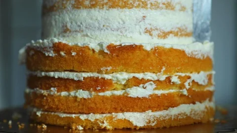 Spinning preparing a simple two-story cake while smearing cream 스톡 동영상 107645496