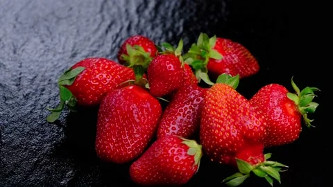 Spinning ripe strawberries on a black background Stock Footage 167282231