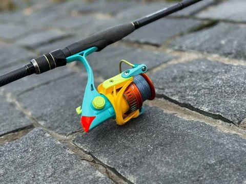 Spinning rod, lying on the background of a river or lake Stock Photos