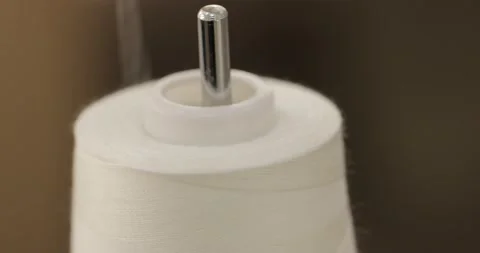 Spinning roll thread spins and the thread turns into the sewing machine. macro Stock Footage 171609757