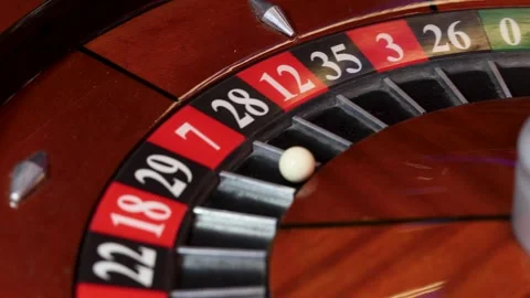 Spinning roulette wheel with numbered pockets and ball in 7 position Stock Footage 336406357