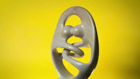 Spinning Statue of Couple Unity on Yellow Background Stock Footage 307679290
