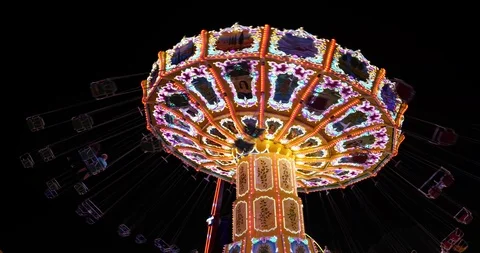 Spinning swing ride or swing carousel on background of night dark sky Stock Footage