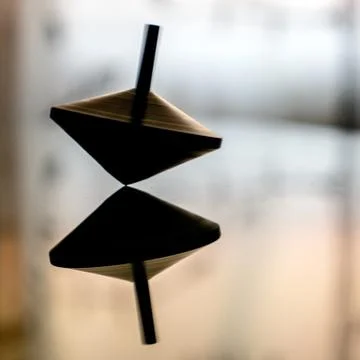 Spinning top in action on a mirror surface Stock Photos