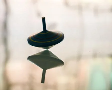 Spinning top in action on a mirror surface Stock Photos